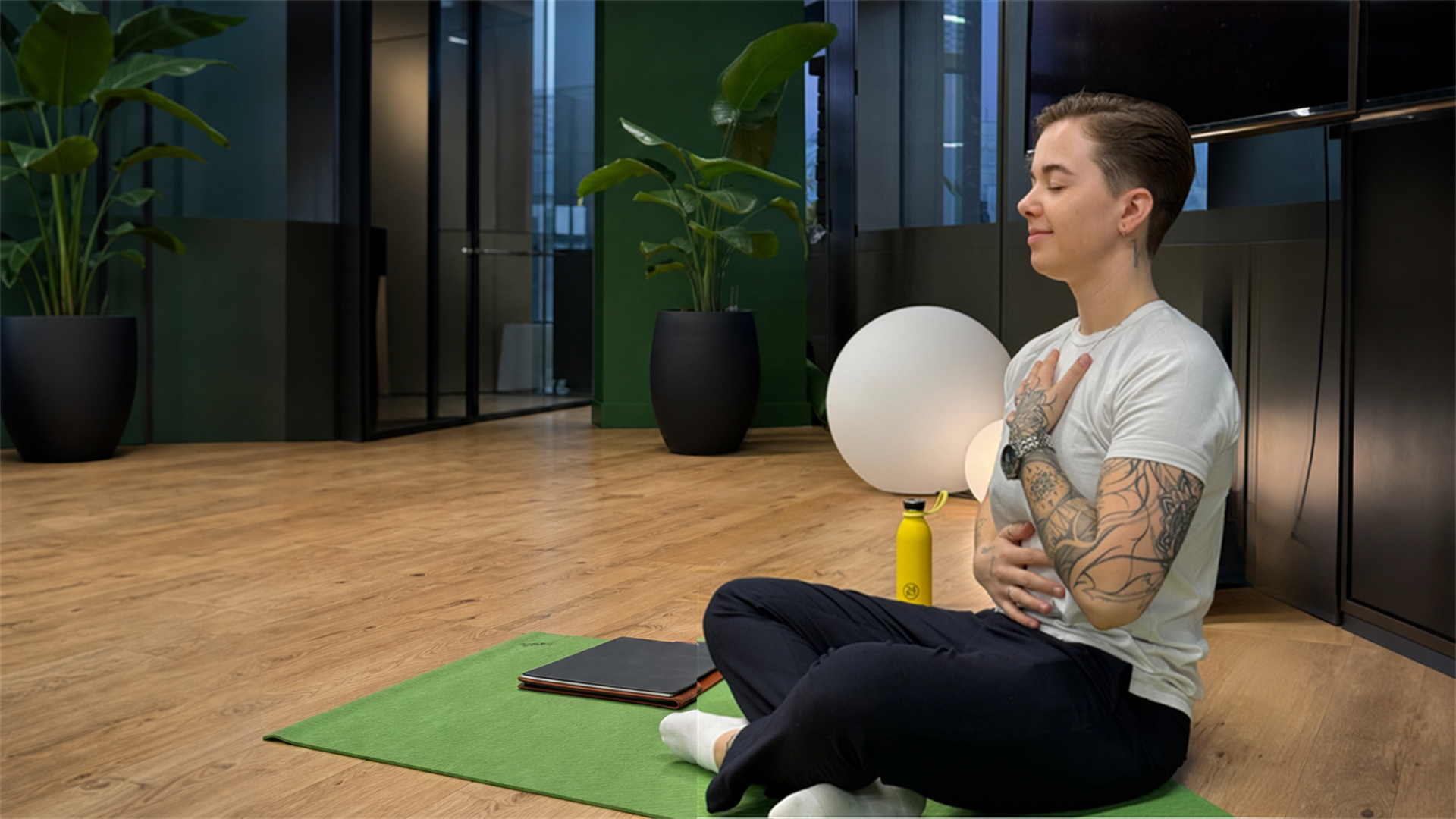 Iva seated during a breathwork practice with one hand over her heart